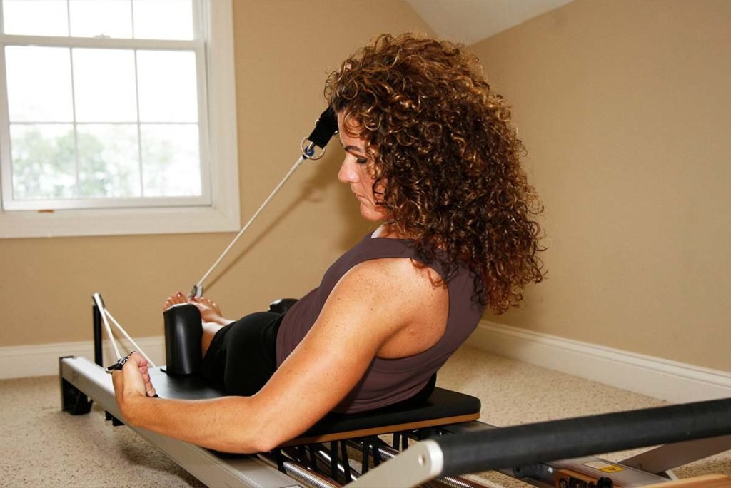 Woman exercising on a Pilates reformer machine