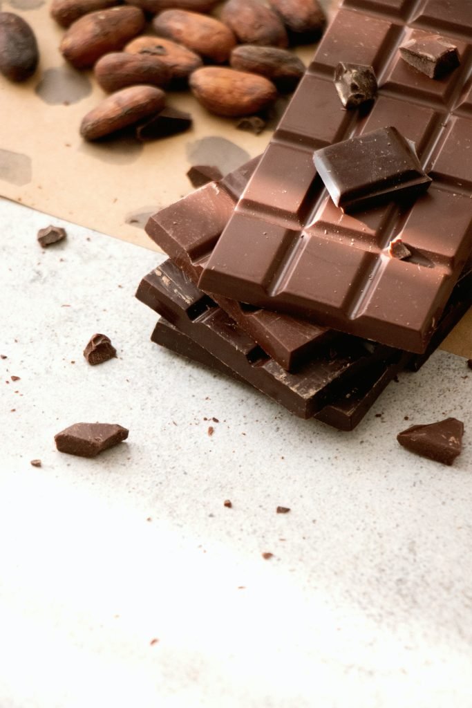 Chocolate bars with cocoa beans and scattered chocolate pieces