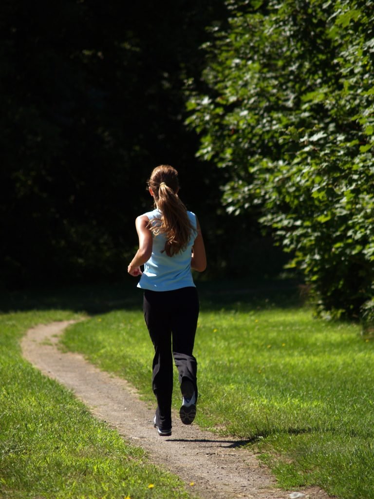 Woman jogging on a winding park trail