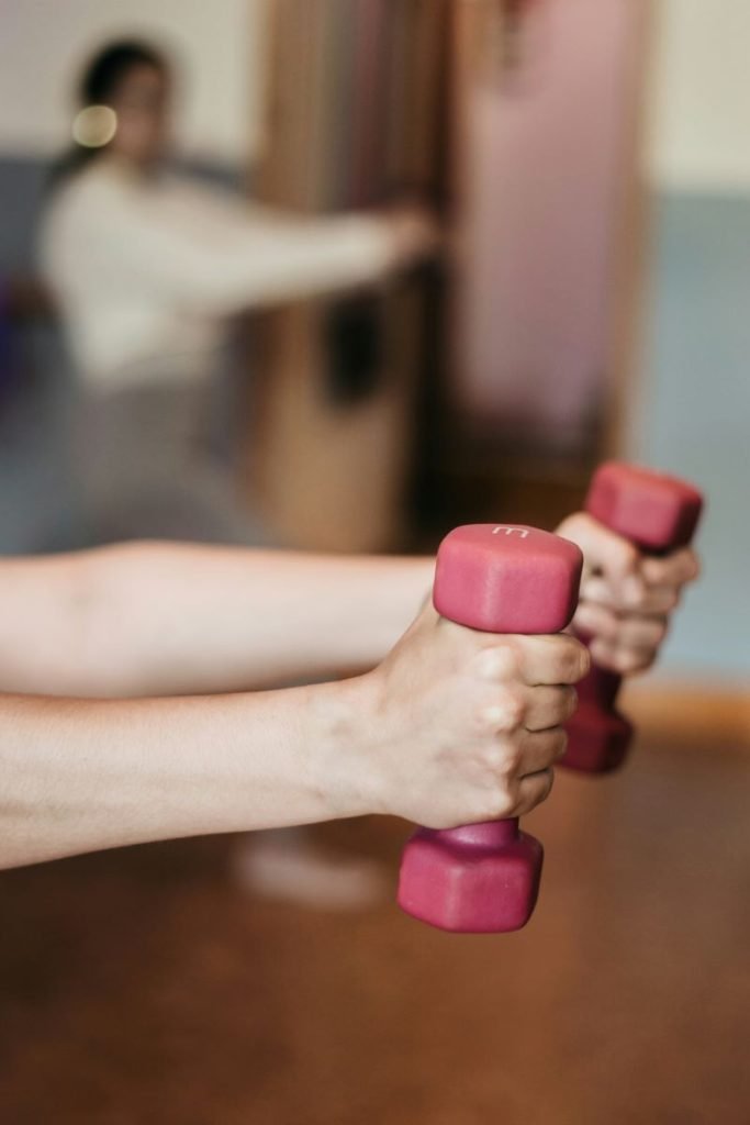 A woman performing confidential fitness training with two weights