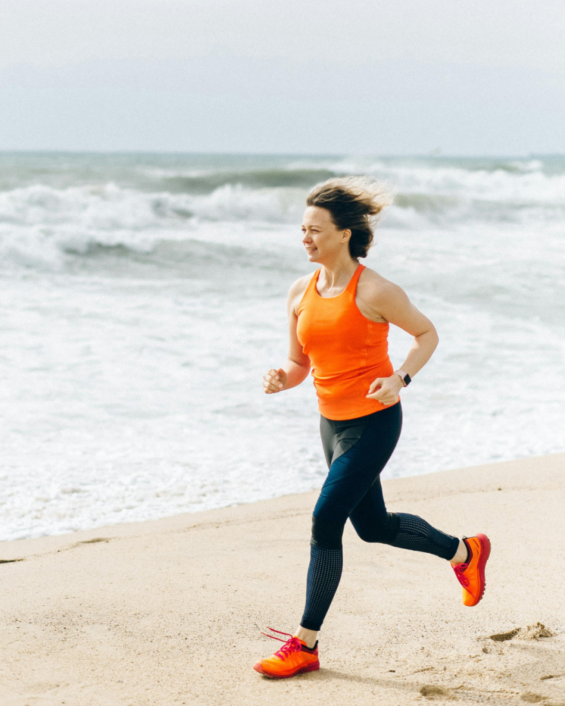 Woman jogging on a beach beside the ocean