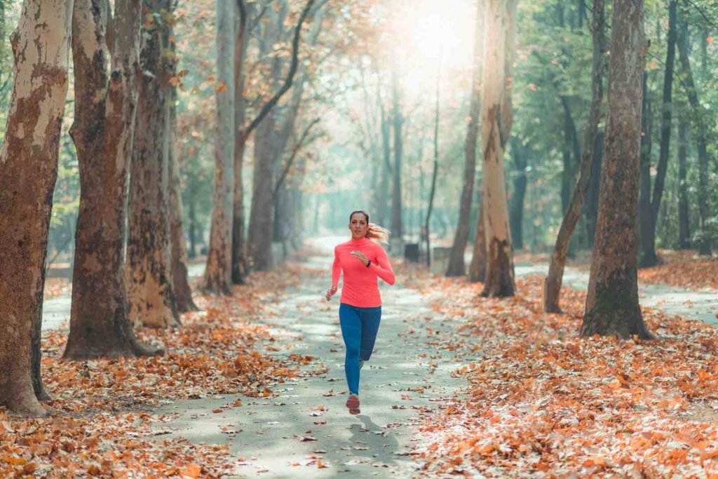 Woman running on a tree-lined path in a park