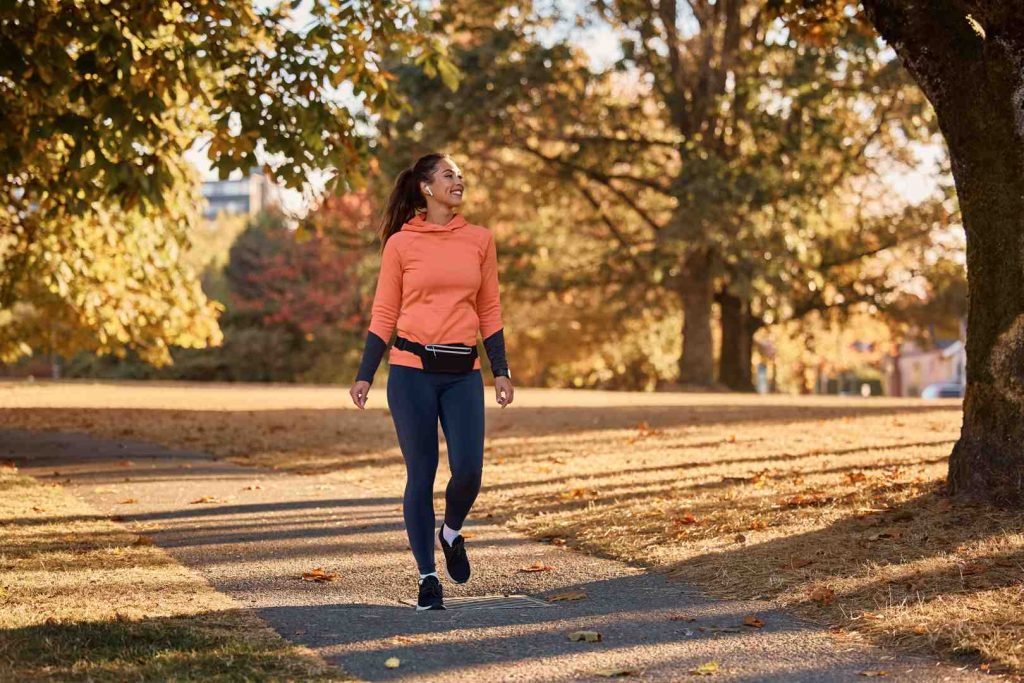Woman jogging on a park path in autumn