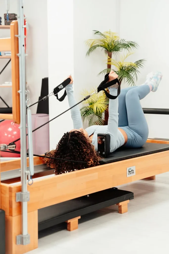 woman over 40 practicing pilates reformer exercise in a bright peaceful studio